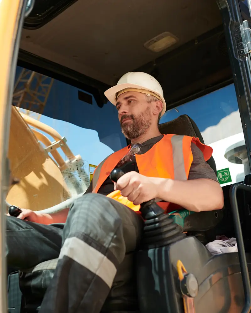 Ekskavator operatoru fərdi mühafizə vasitələri ilə